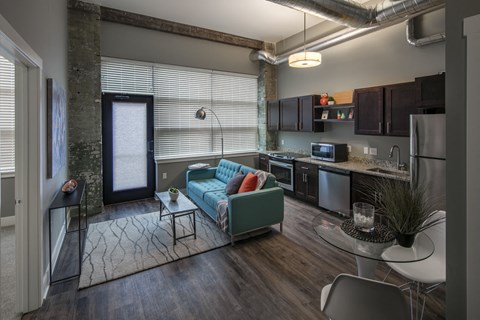 a living room and kitchen with a blue couch and a table